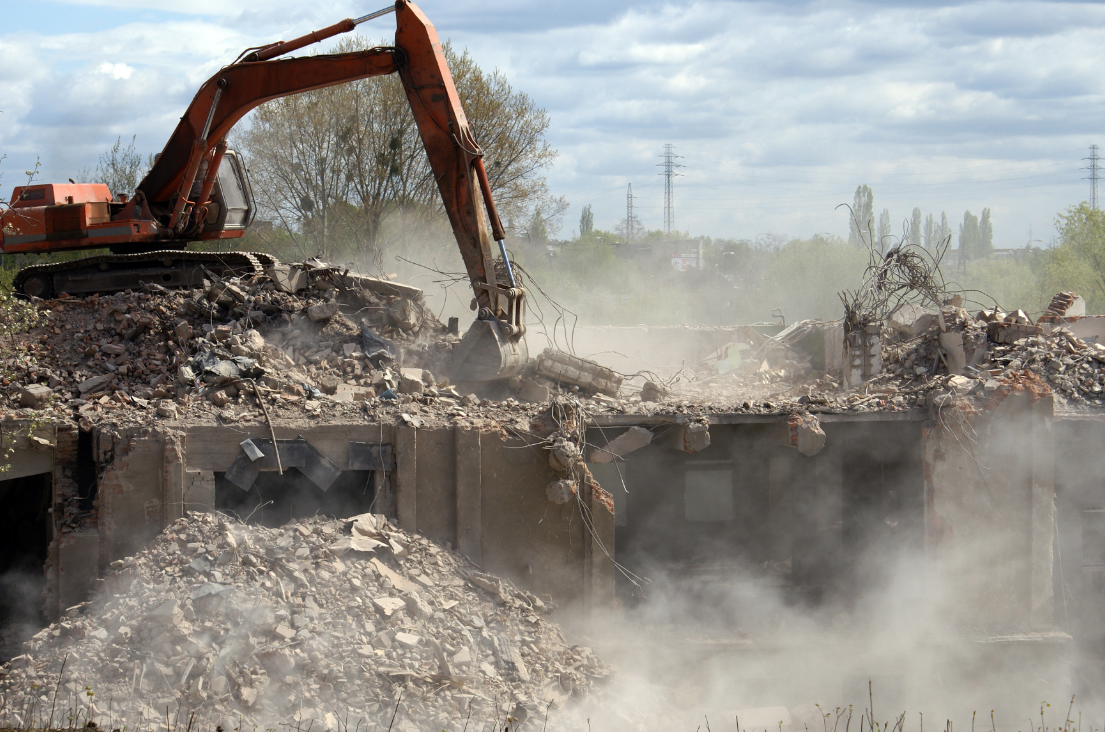 Excavating & Grading Services Muskego WI – An excavator working amidst the dust at a building demolition site. Excavating & Grading Services Muskego WI - An excavator working amidst the dust at a building demolition site.